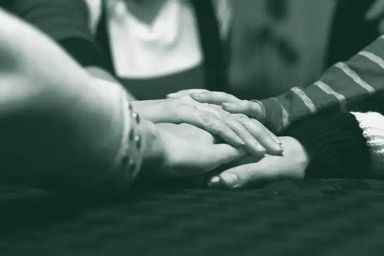 Manos de tres generaciones apoyadas una sobre otra